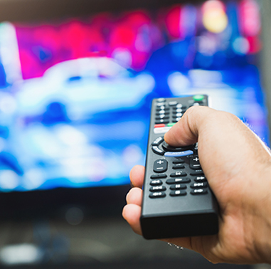 Man holding television remote and pointing it at television
